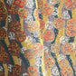 Japanese silkscreen chiyogami paper with a traditional botanical circle motif in tones of mustard, inky blue, lilac and gold.