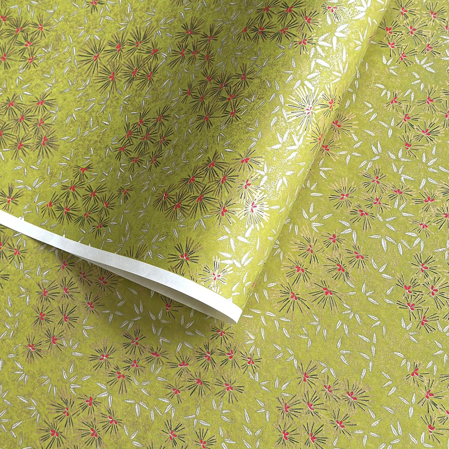 Pattern of scattered pine needles (matsuba) in gold and silver on an olive backdrop.  Japanese chiyogami paper