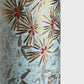 Japanese chiyogami paper silkscreen printed with gold pine needle design on a soft aqua backdrop.