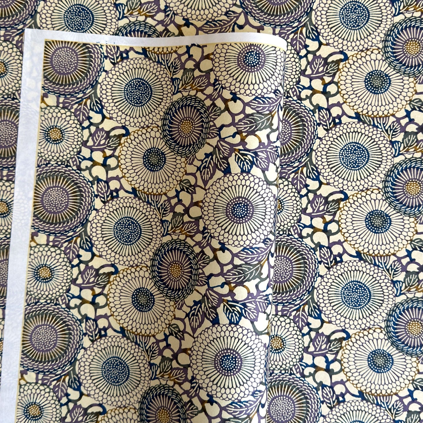 Japanese chiyogami silkscreen printed paper with a floral kiko pattern in purple and blue on a cream backdrop
