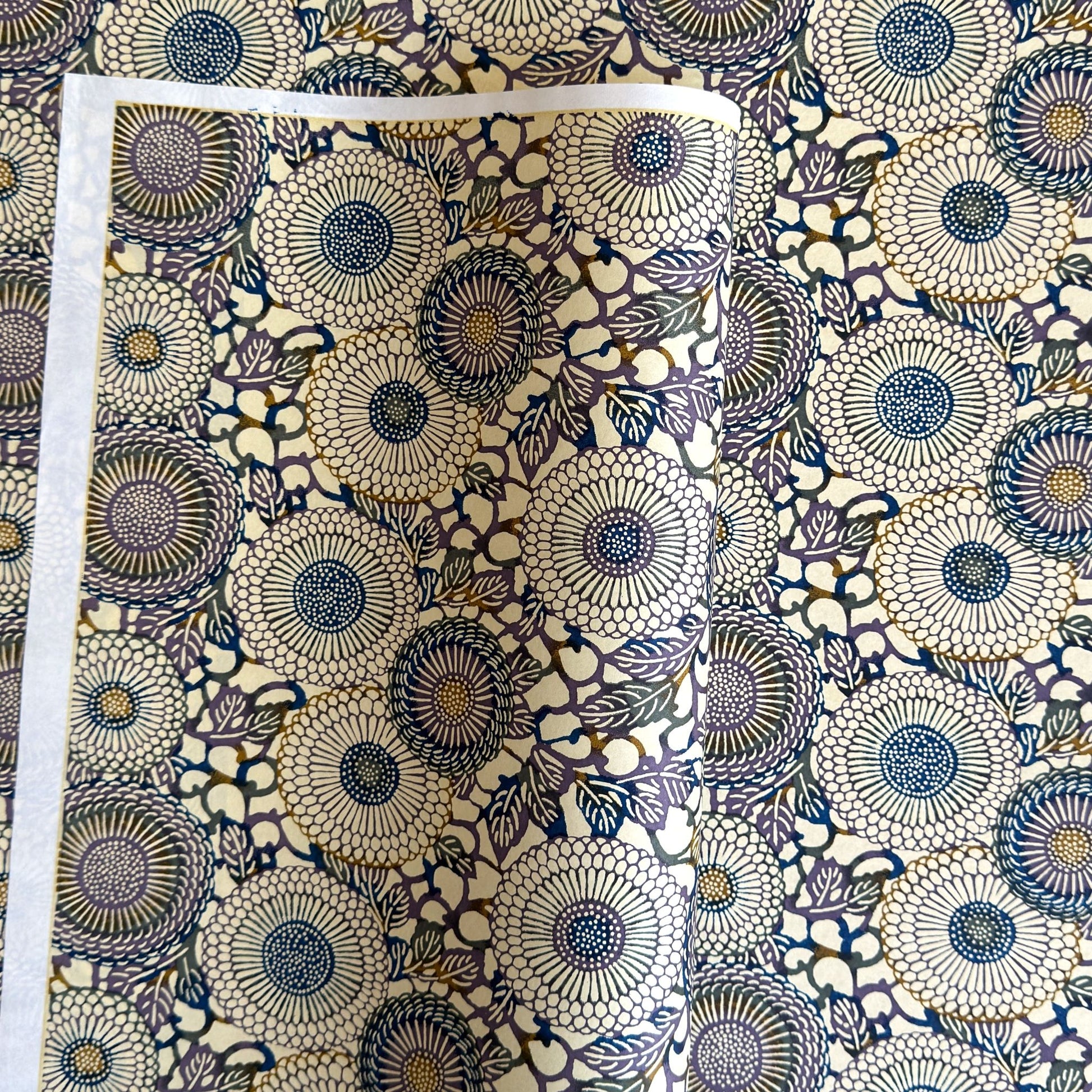 Japanese chiyogami silkscreen printed paper with a floral kiko pattern in purple and blue on a cream backdrop