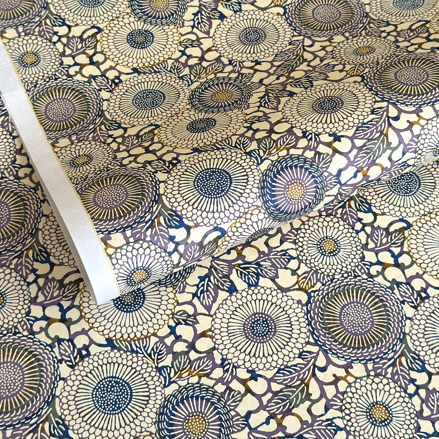 Japanese chiyogami silkscreen printed paper with a floral kiko pattern in purple and blue on a cream backdrop