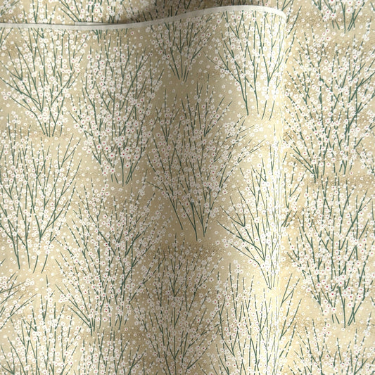 a sheet of Japanese silkscreen printed chiyogami paper with a delicate design of tufts of meadow grasses in flower in white, green on a cream background