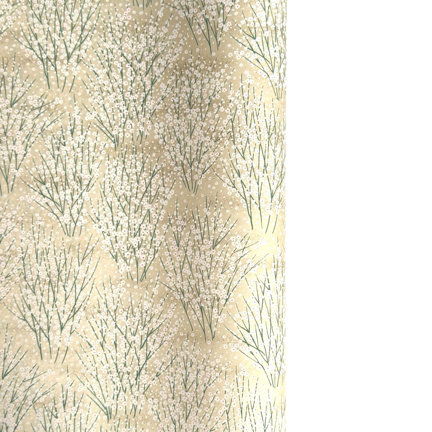 a sheet of Japanese silkscreen printed chiyogami paper with a delicate design of tufts of meadow grasses in flower in white, green on a cream background