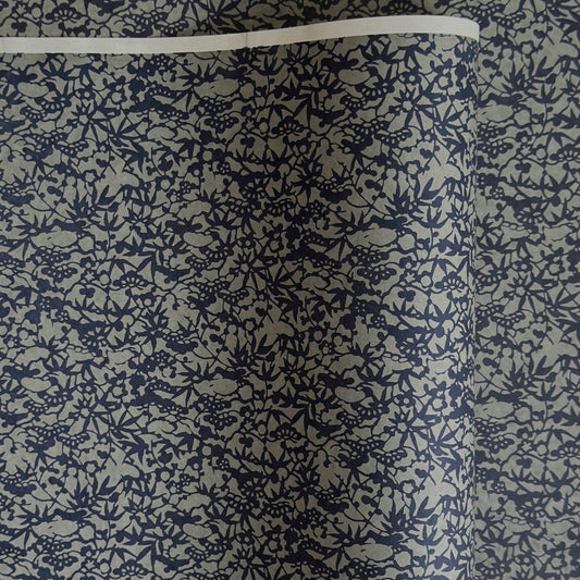 a sheet of Japanese chiyogami yuzen paper with a small abstract pattern in midnight blue on grey