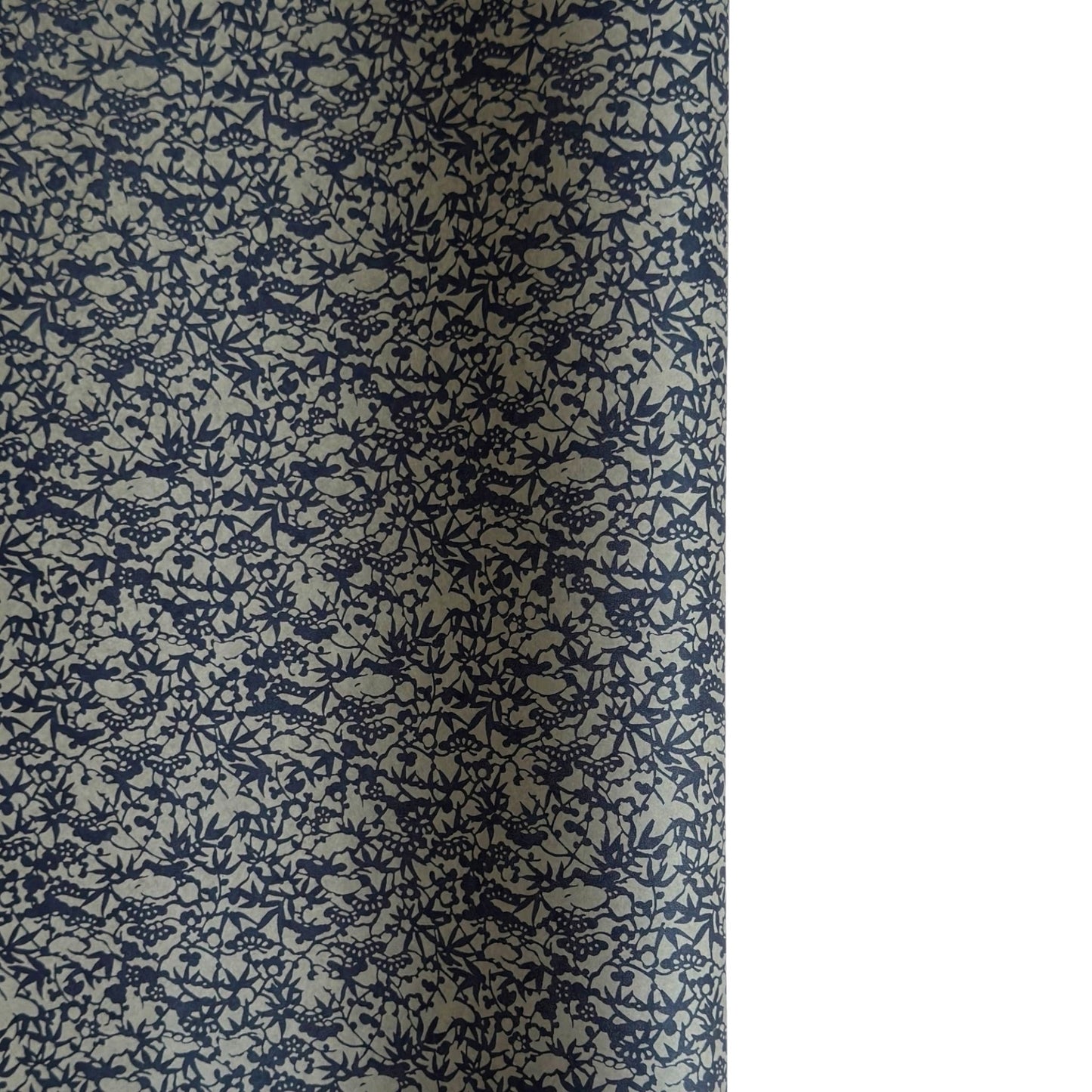 a sheet of Japanese chiyogami yuzen paper with a small abstract pattern in midnight blue on grey