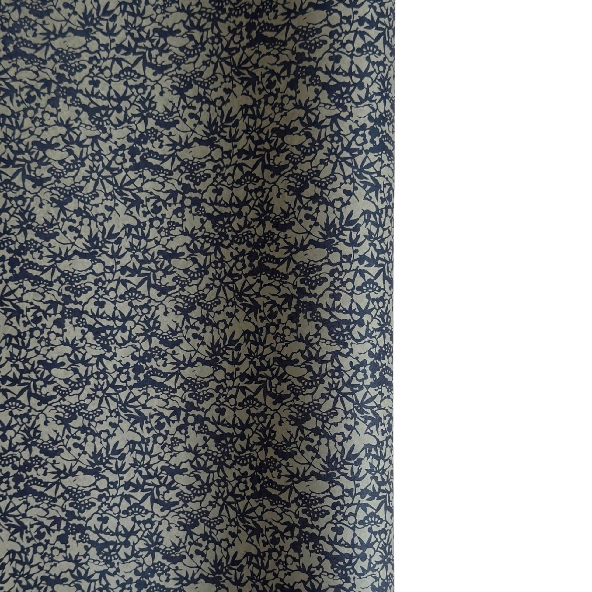 a sheet of Japanese chiyogami yuzen paper with a small abstract pattern in midnight blue on grey