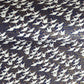 Japanese chiyogami paper with a silkscreened pattern of white cranes in flight on a midnight blue and gold background.