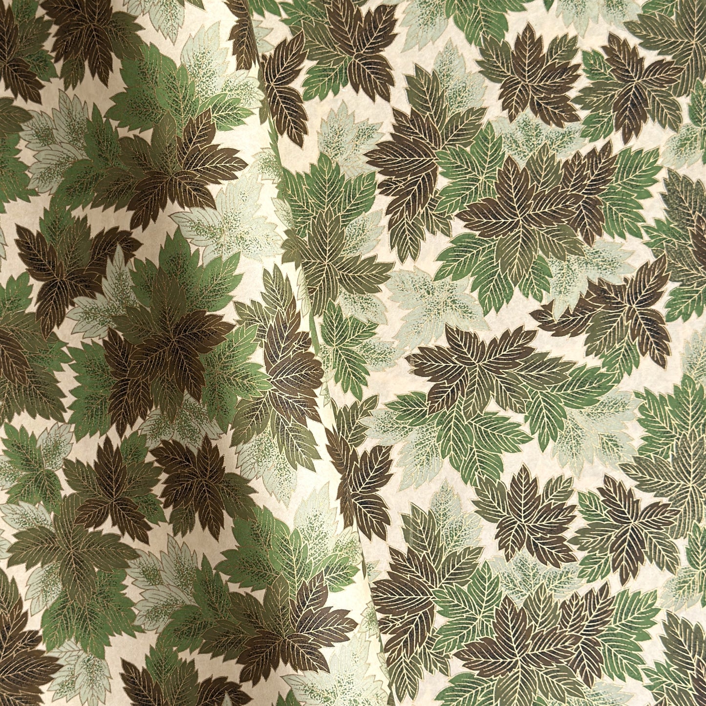 Japanese chiyogami paper with a pattern of green leaves in various tones with gold accent.