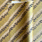 Japanese chiyogami paper with a design of trees, bamboo and plum blossom in indigo, green and white on a vintage gold backdrop. 