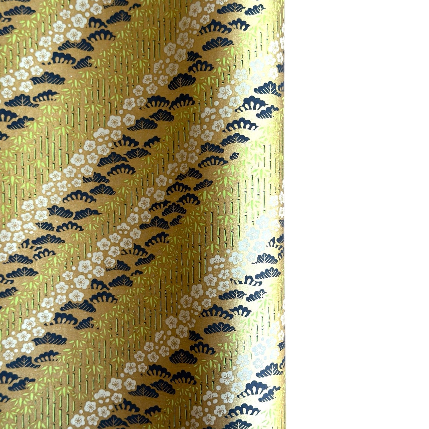 Japanese chiyogami paper with a design of trees, bamboo and plum blossom in indigo, green and white on a vintage gold backdrop. 