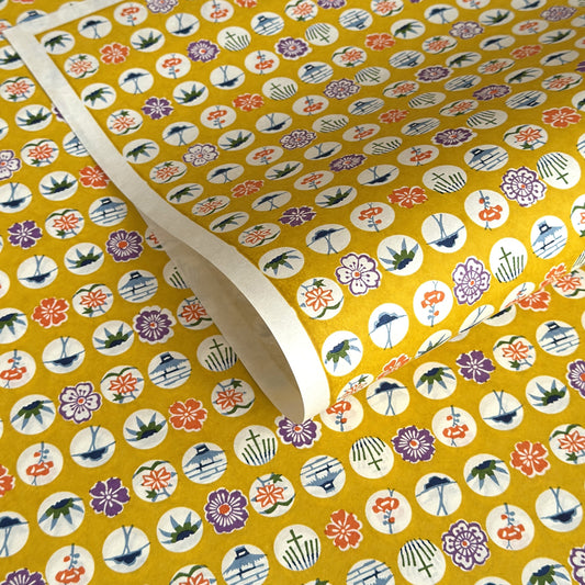 japanese silk-screen handmade paper showing circles of traditional motifs on yellow backdrop