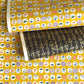 japanese silk-screen handmade paper showing circles of traditional motifs on yellow backdrop