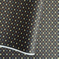 Japanese silkscreen chiyogami paper with a pattern of small repeat motifs in red, blue, lemon and gold on a black background