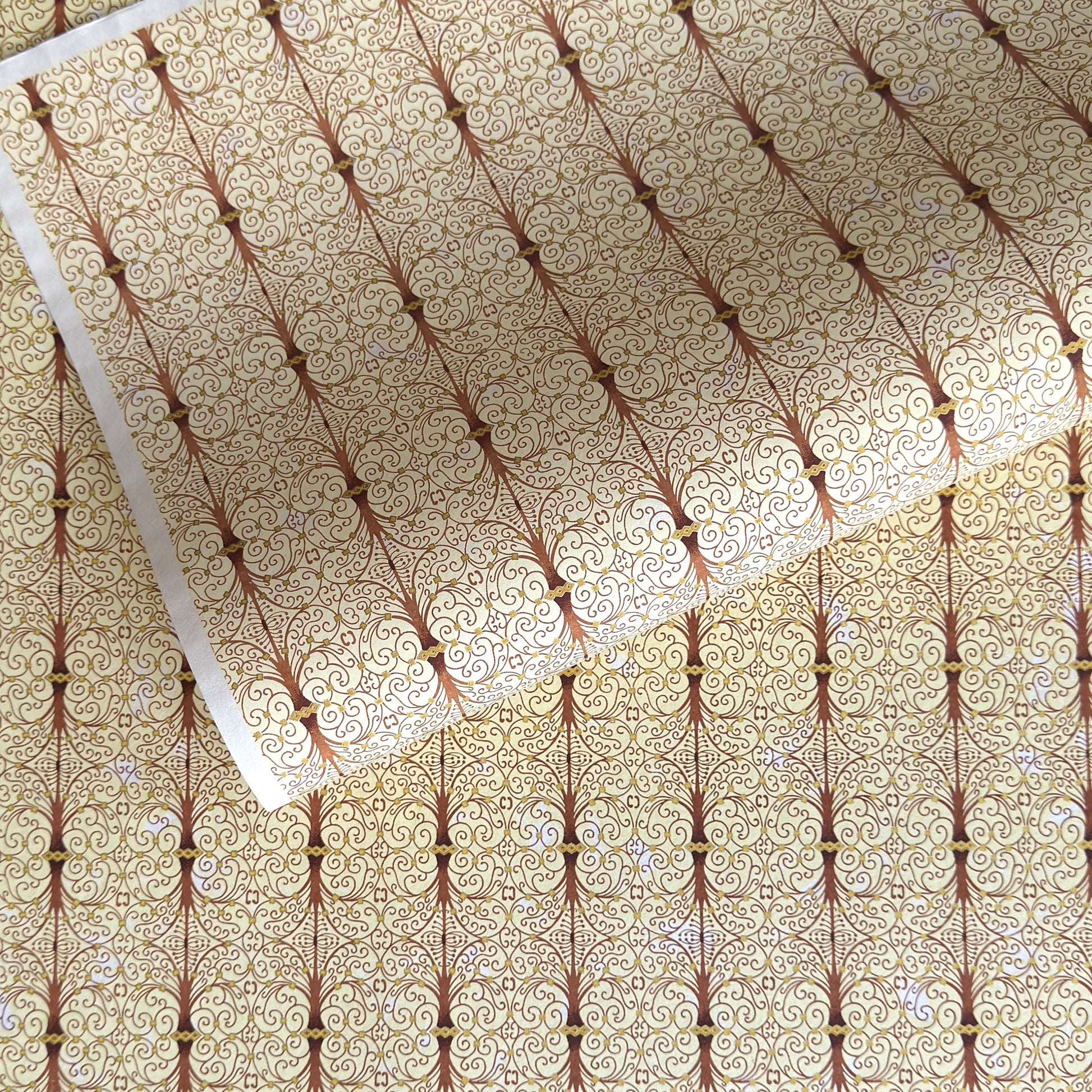 Japanese silkscreen chiyogami paper with a intricate filigree trellis design in brown with gold accent