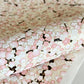 Japanese chiyogami paper with pale pink plum blossom, dark brown branches on an ivory background. Close-up