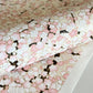 Japanese chiyogami paper with pale pink plum blossom, dark brown branches on an ivory background. Closeup
