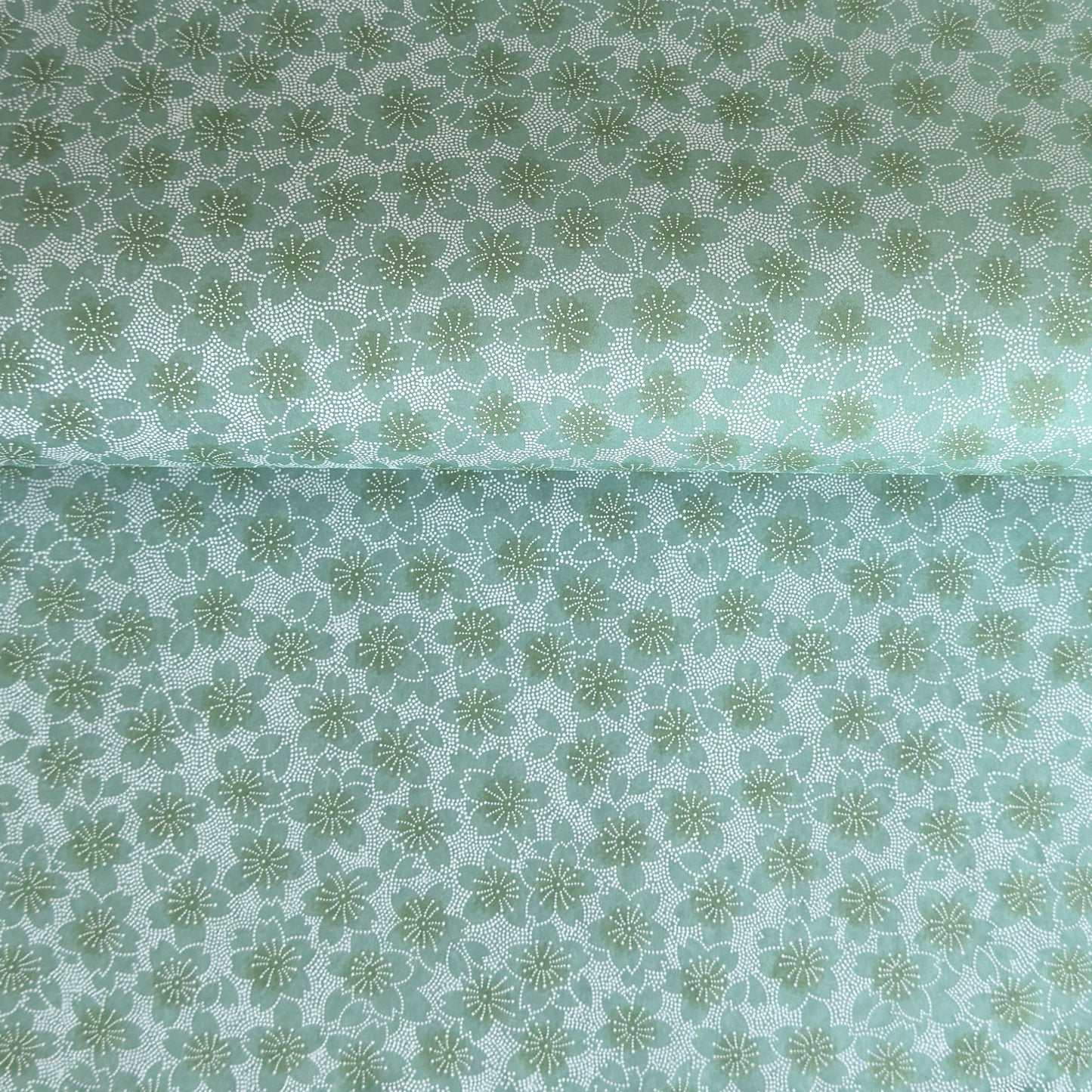 japanese silk-screen paper, chiyogami, with a cherry blossom flower repeat pattern in turquoise and white