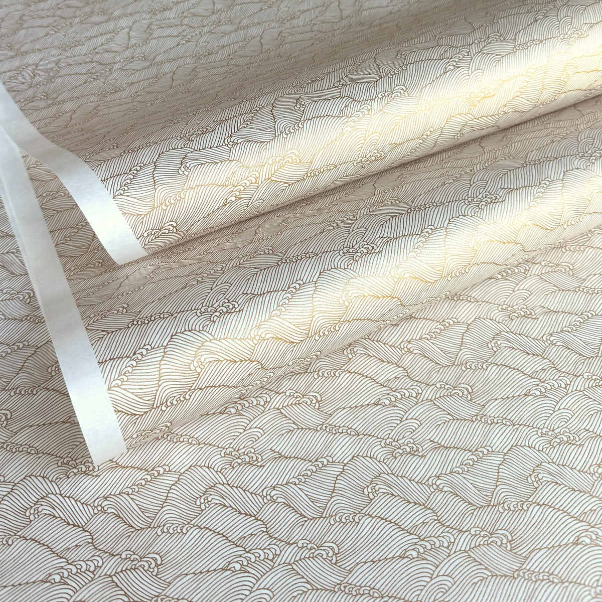 a sheet of Japanese silkscreen printed chiyogami paper with a copper wave design on white ground