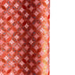 A close-up of a sheet of Japanese chiyogami paper featuring a repeating geometric medallion design in shades of terracotta red, coral pink, and metallic gold