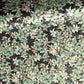 a sheet of Japanese chiyogami screen printed paper with a pattern of light green foliage on a black ground with silver botanical details