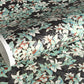 a sheet of Japanese chiyogami screen printed paper with a pattern of light green foliage on a black ground with silver botanical details
