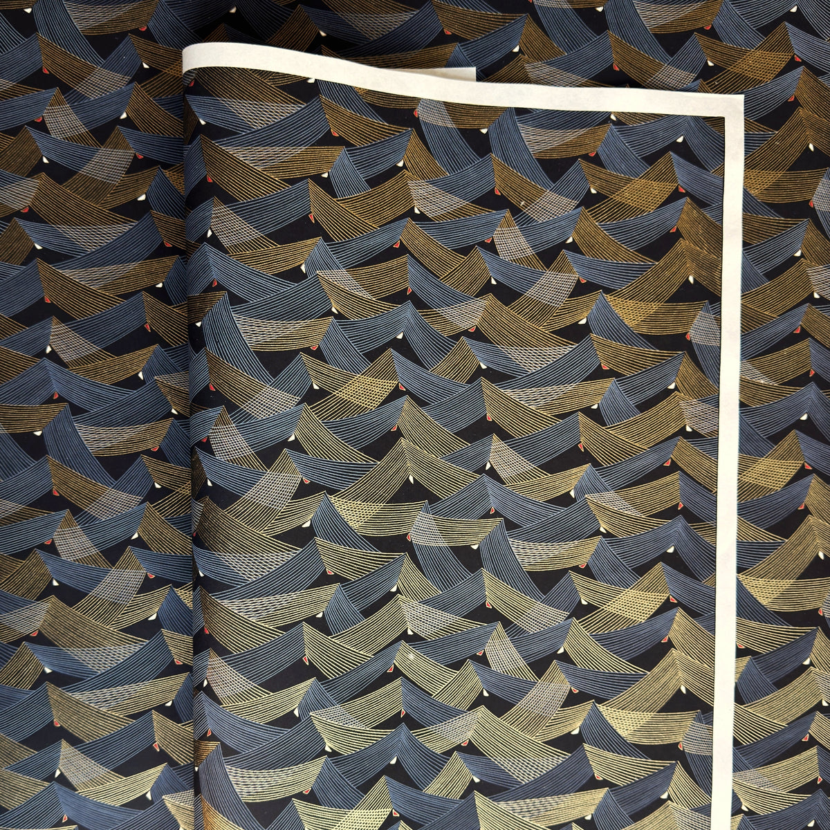 a sheet of Japanese chiyogami paper with gold and silver chevron stripes on black ground