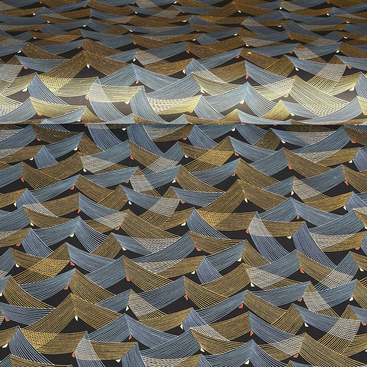 a sheet of Japanese chiyogami paper with gold and silver chevron stripes on black ground