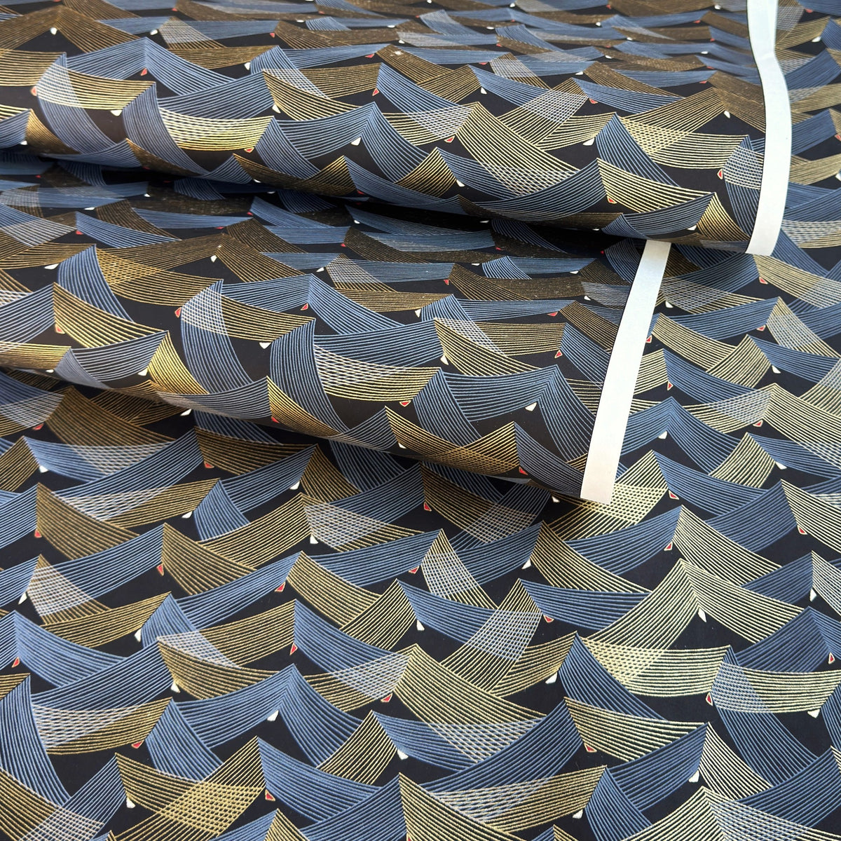 a sheet of Japanese chiyogami paper with gold and silver chevron stripes on black ground