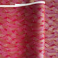 a sheet of Japanese chiyogami paper with a pattern of gold and pink striped chevron lines on fuchsia ground