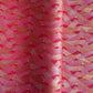 a sheet of Japanese chiyogami paper with a pattern of gold and pink striped chevron lines on fuchsia ground