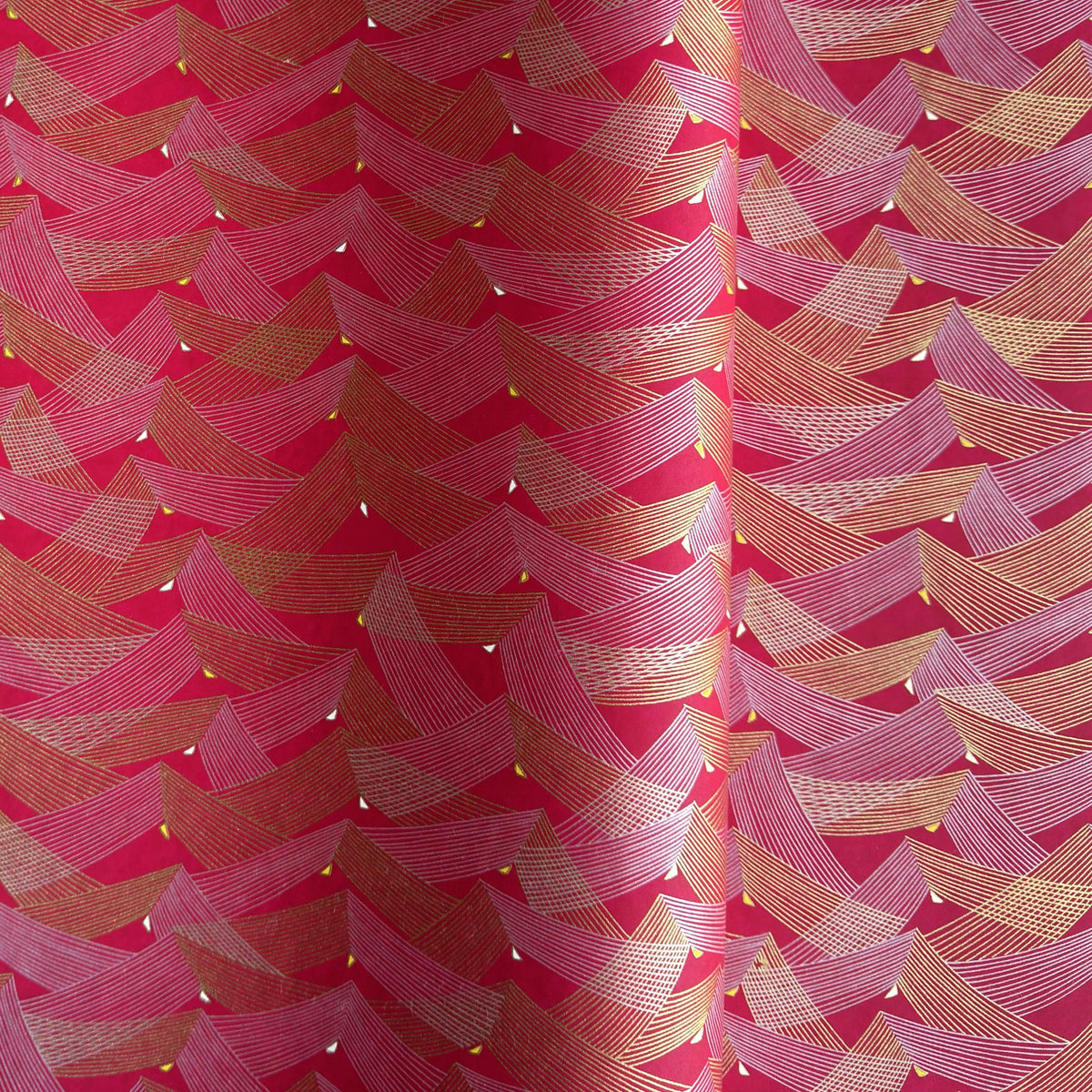a sheet of Japanese chiyogami paper with a pattern of gold and pink striped chevron lines on fuchsia ground