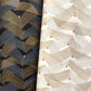 a close of of two sheet of Japanese chiyogami paper with chevron patterns. On the left a version in black with gold and silver and on the right a white version.
