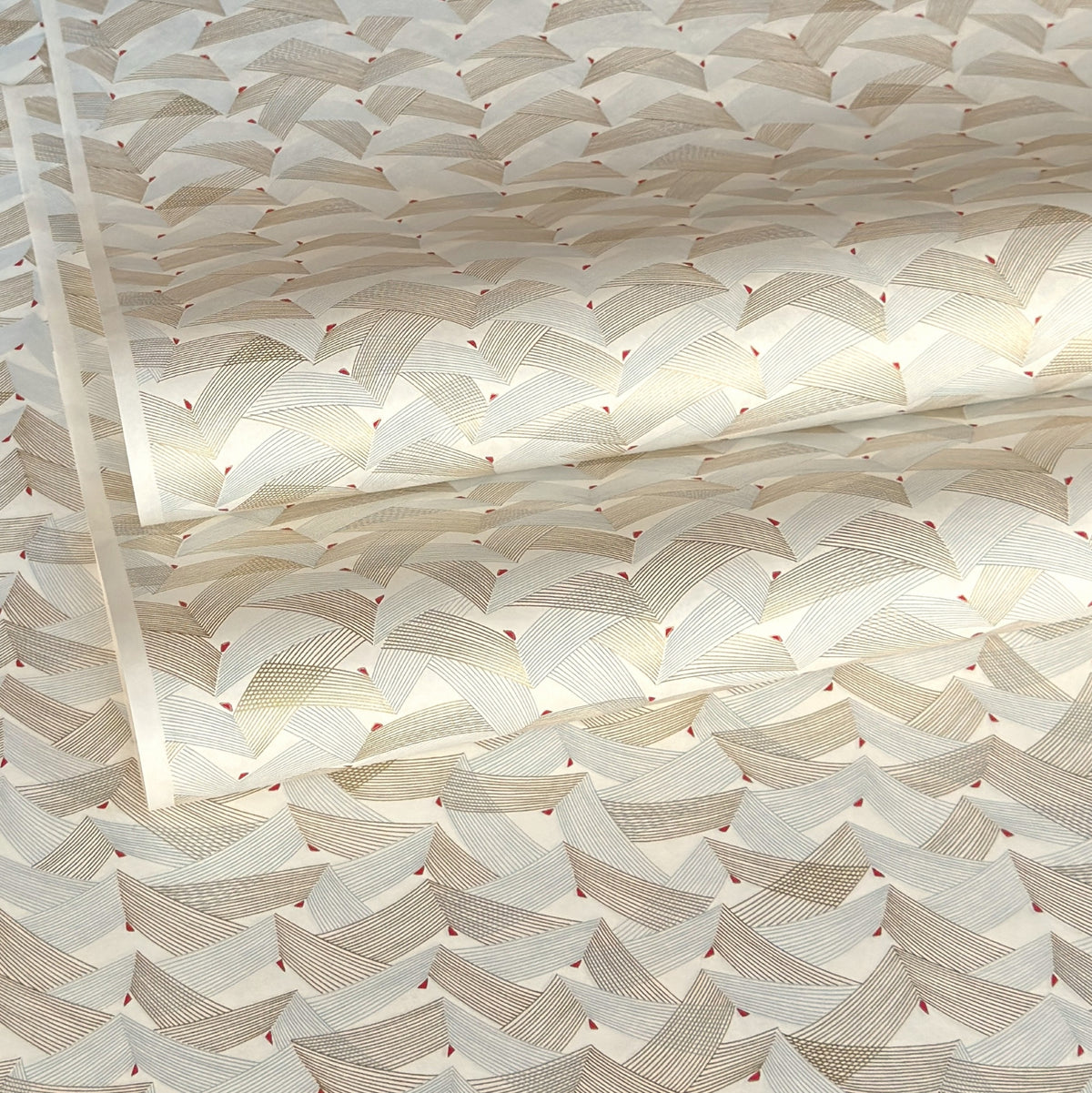 a sheet of Japanese chiyogami paper with gold and silver chevron lines on white paper