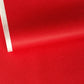 A close-up of a bright red sheet of chiyogami paper with a fine dotted pattern in gold. 