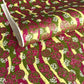 a sheet of Japanese chiyogami yuzen paper with wavy stripes in magenta, green and yellow, overlaid with circles with delicate flowers in the middle and outlined in gold.