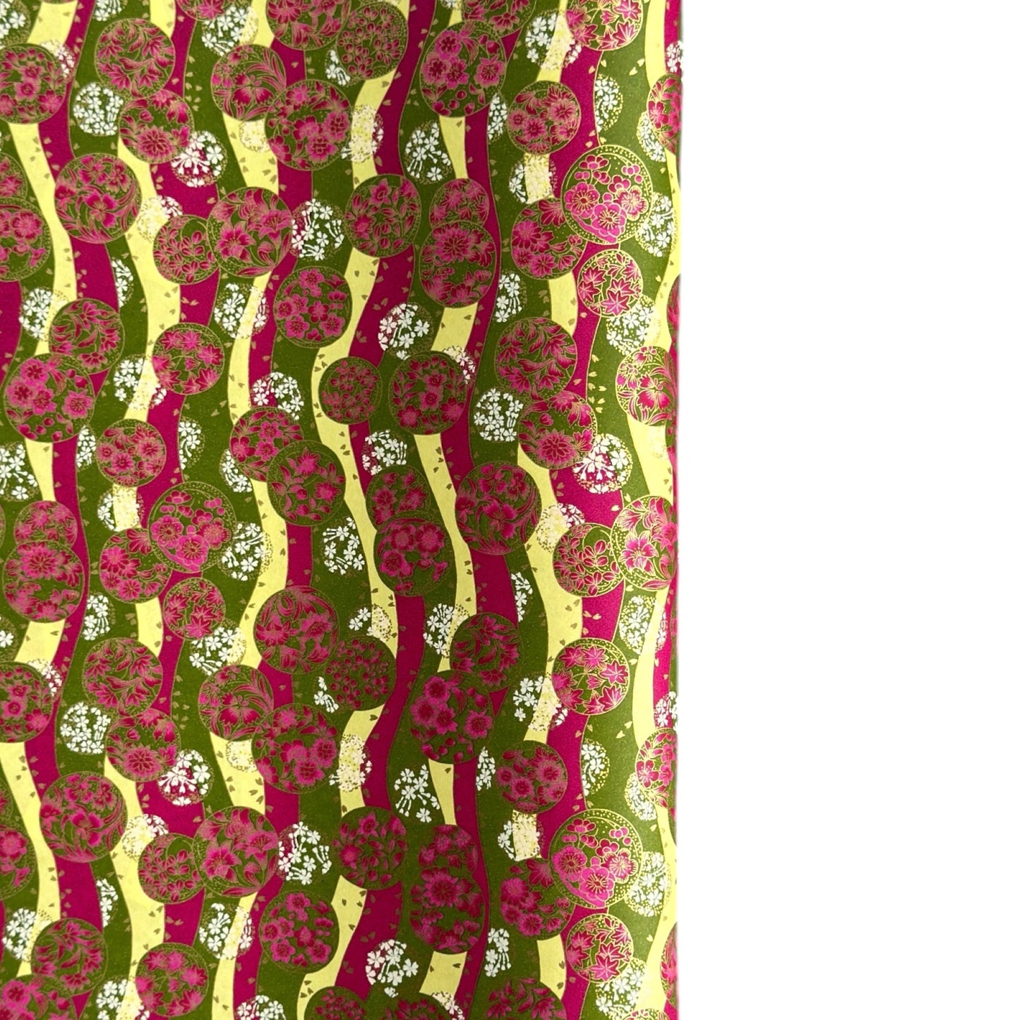 a sheet of Japanese chiyogami yuzen paper with wavy stripes in magenta, green and yellow, overlaid with circles with delicate flowers in the middle and outlined in gold.