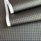 a sheet of Japanese chiyogami paper with a check plaid design in grey, black and gold