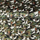 A close-up of a sheet of Japanese chiyogami paper featuring white cranes flying over green pine trees and branches on a black background.