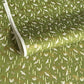 a sheet of Japanese chiyogami paper with an olive green ground and a pattern of white flying cranes and arrows.  There are also little pink cherry blossom flowers and gold clouds.