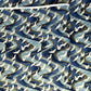 a sheet of Japanese Chiyogami paper with a hand screen printed pattern of white cranes in flight. The backdrop is swirling lines of dark and light blue with gold accents.