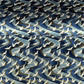 a sheet of Japanese Chiyogami paper with a hand screen printed pattern of white cranes in flight. The backdrop is swirling lines of dark and light blue with gold accents.