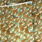 a sheet of Japanese chiyogami yuzen paper screen printed with a pattern of white flying cranes on a background of aqua and tan swirling lines