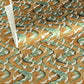 a sheet of Japanese chiyogami yuzen paper screen printed with a pattern of white flying cranes on a background of aqua and tan swirling lines