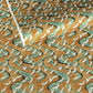 a sheet of Japanese chiyogami yuzen paper screen printed with a pattern of white flying cranes on a background of aqua and tan swirling lines