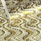 a sheet of Japanese chiyogami paper hand screen printed with a pattern of white cranes in flight.  The back drop is silver and lack swirling lines on gold. 