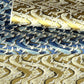 sheets of Japanese chiyogami paper with patterns of white cranes in flight on a backdrop of swirling lines.  The top of bottom papers pictured are in gold, the middle one is blue.