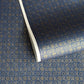 A sheet of Japanese chiyogami paper with a small repeat pattern of gold circular crests on a dark blue background.