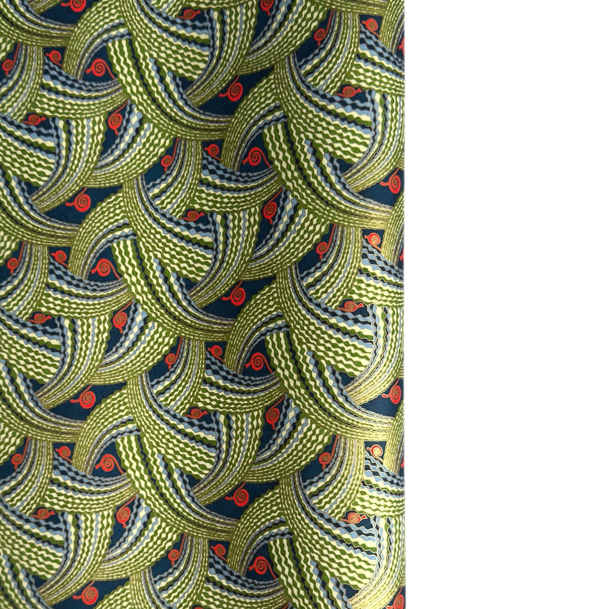 A close-up of a sheet of Japanese chiyogami paper with repeating curved wave-like motifs in olive green, navy blue, white, and small orange-red accents. 