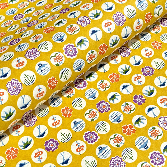japanese silk-screen handmade paper showing circles of traditional motifs on yellow backdrop